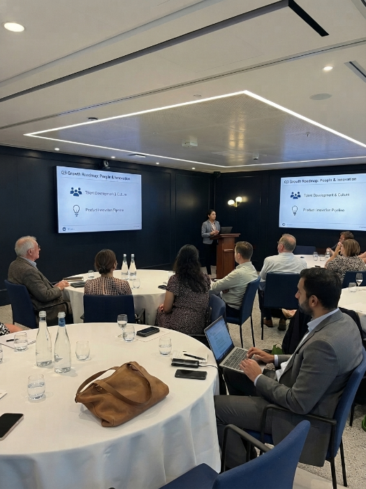 The TotalOps Automation team presenting a Q3 growth roadmap on people and innovation to business leaders at a boardroom event.